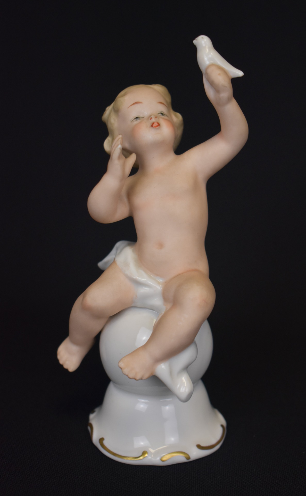 Statuetă din porțelan Wallendorf – copil nud ținând o pasăre în mână, vedere frontală